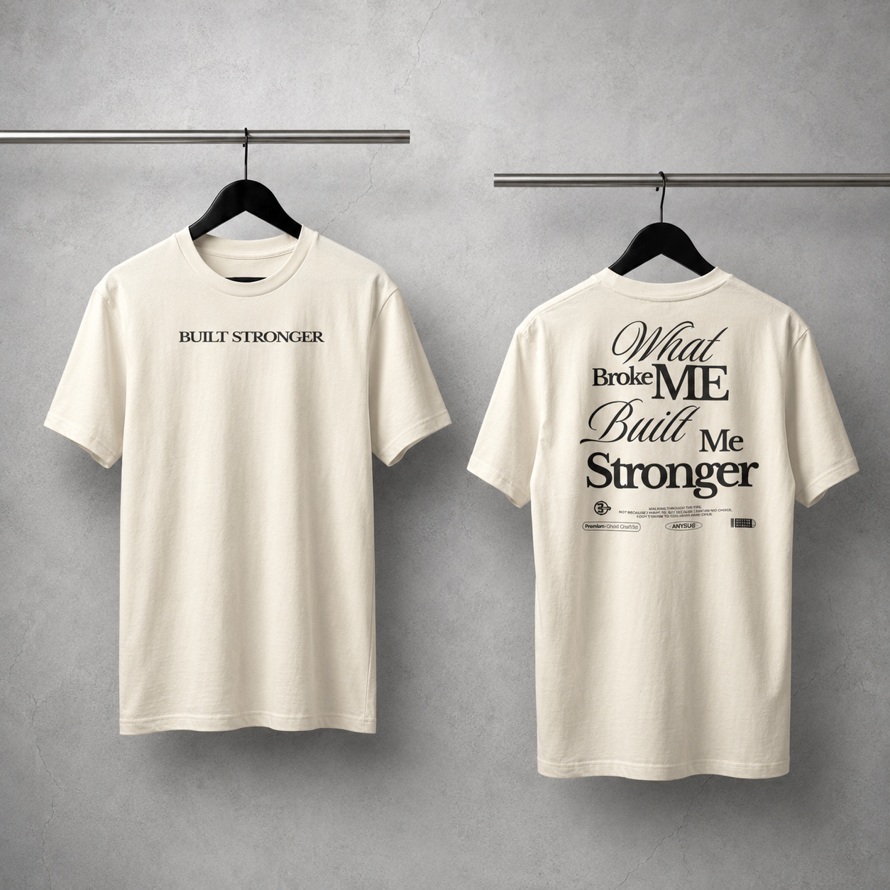 Two white t-shirts with motivational phrases on hangers against a gray background